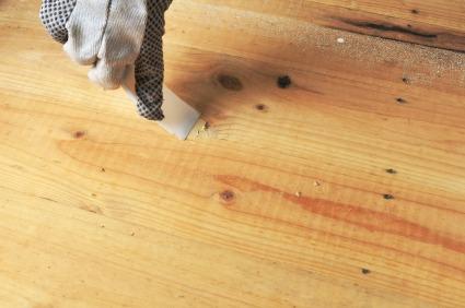 Applying latex wood filer to pine board.